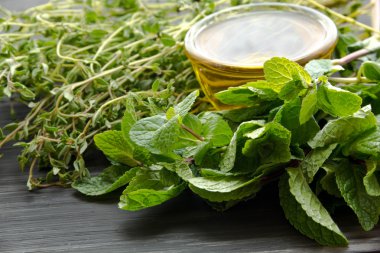 Ahşap masa üzerinde taze nane ve kimyon yağı