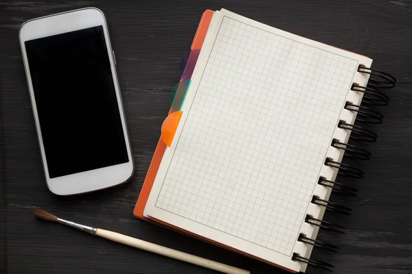 Maquette et smartphone sur le fond vieille table noire — Photo