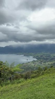 Maninjau Gölü manzarası, Endonezya 'nın batısındaki Agam kentindeki ünlü bir turizm merkezi olan Puncak Lawang' dan alınan yeşil tepelerle çevrili.
