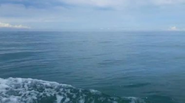 Endonezya, Pariaman 'daki bir tekneden güzel bir okyanus manzarası köpüklü dalgalar ve denizde bulutlu bir gökyüzü.