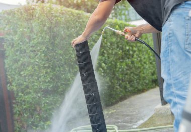 Açık havada su püskürten bir klima kısmen temizlik servisi. Klima bakım servisi. Ev hizmetleri kavramı.