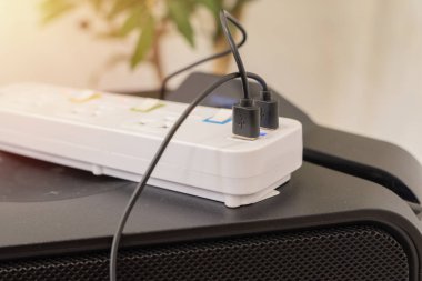 Uzatma gücü ile siyah USB kablosu ve adaptör şarj prizlerinin yan görüntüsü. Enerji yönetimi ve elektrik enerjisi tasarrufu kavramı