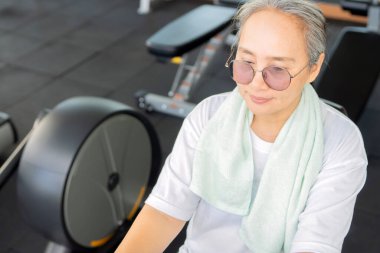 Çekici bir Asyalı kadının spor salonunda egzersiz yaparken yüksek açılı görüntüsü. Emeklilik ve sağlık yaşam tarzı ve konsept 