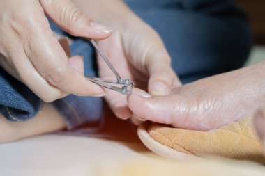 Yaşlı yaşlıların vücut temizliğine yakın çekimleri, ayak tırnaklarını keserek, pedikür tırnak makasıyla, bakım evinde hijyen yardımı....