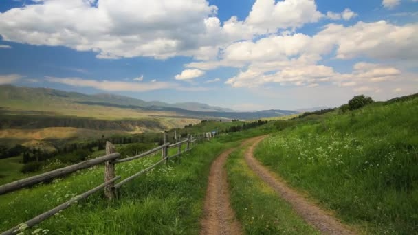 La cerca a lo largo del camino rural en las montañas — Vídeos de Stock