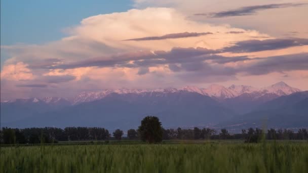 Campo e pôr-do-sol nuvens sobre as montanhas — Vídeo de Stock