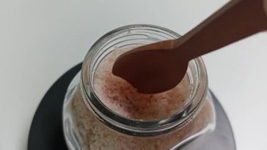 Cam kavanozda pembe Himalaya tuzu yığını. Egzotik mutfak malzemeleri. Döndürme