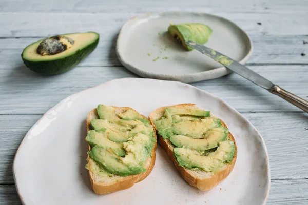 Sandwich avocat sur une assiette blanche faite à la main — Photo