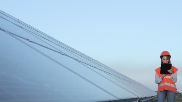 インスペクタエンジニア女性ソーラーパネルで働くデジタルタブレットを保持するパワーファーム 太陽電池パーク グリーンエネルギーコンセプト — ストック動画