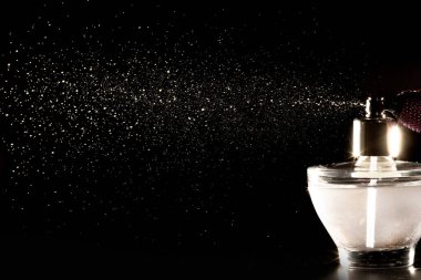Siyah arka planda parfüm şişesi spreyi..