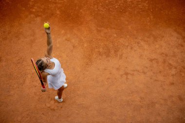 Beyaz spor giyimli tenisçi tenis topu servis etmeye hazırlanıyor, maçtan önce antrenman var..