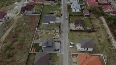 Konut arazilerindeki evlerin havadan görünüşü, kimisi çatı panelleri olan evler.