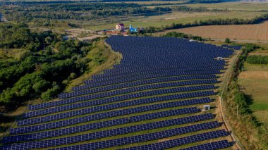 Güneşli bir günde Green Field 'daki Güneş Enerjisi İstasyonu' nun Aerial Top görüntüsü. İnsansız hava aracı Güneş Çiftliği üzerinde uçuyor. Bir sürü Güneş Paneli Güç Üretimi için sırada bekliyor. Yenilenebilir yeşil enerji