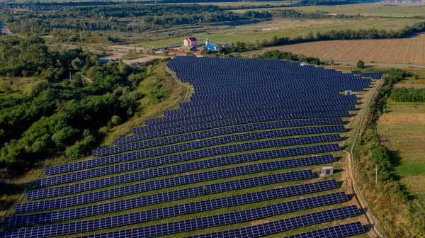 Güneşli bir günde Green Field 'daki Güneş Enerjisi İstasyonu' nun Aerial Top görüntüsü. İnsansız hava aracı Güneş Çiftliği üzerinde uçuyor. Bir sürü Güneş Paneli Güç Üretimi için sırada bekliyor. Yenilenebilir yeşil enerji
