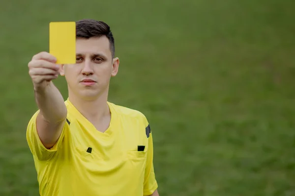 Referee showing a yellow card to a displeased football or soccer player while gaming. Concept of sport, rules violation, controversial issues, obstacles overcoming