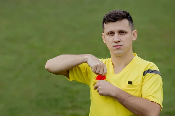 Referee showing a red card to a displeased football or soccer player while gaming. Concept of sport, rules violation, controversial issues, obstacles overcoming