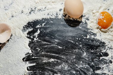 Taze pişmiş makarna, un tozuyla kaplanmış karanlık bir yüzeyde yatıyor. İtalyan makarnası. Tagliatelle. Çiğ makarna. İtalyan makarna tarifi. Üst görünüm, alanı kopyala.