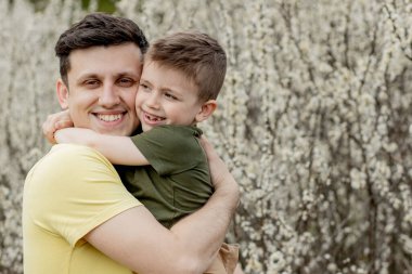 Oğlunu kucağında tutan mutlu bir adamın görüntüsü..