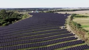 Doğanın güneş panelleri. Sahada uzun sıra mavi fotovoltaik paneller var. Sürdürülebilir enerji kaynağı. Üst hava görüntüsü