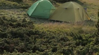 Gün batımında güzel bir dağ sırasının arka planında turist çadırı. Geçitte turist kampı. Dağlarda yürüyüş.
