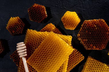 Kavanozda bal ve bal peteği. Siyah tahta bir arka planda. Metin için boş alan. Üst görünüm