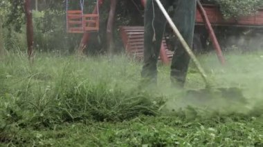 Elinde çim biçme makinesiyle evin önünde çim biçen bir işçi. Bir adamın ellerinde budayıcı. Bahçıvan çimleri biçiyor. Yaşam biçimi