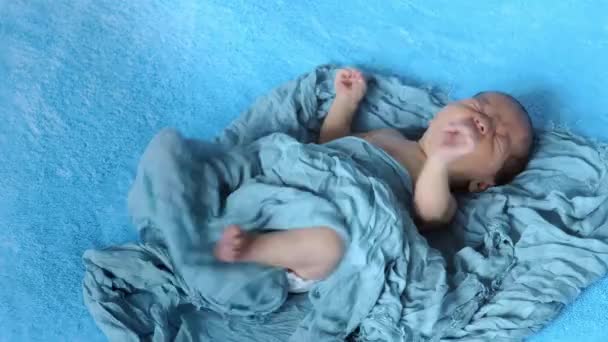 Niño recién nacido llorando. Niño recién nacido cansado y hambriento en la cama bajo manta de punto azul. Los niños lloran. Ropa de cama para niños. Bebé gritando. Niño sano poco después del nacimiento. — Vídeos de Stock