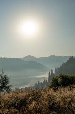 Dağlarda güzel bir gün doğumu, panoramanın altında beyaz bir sis var..