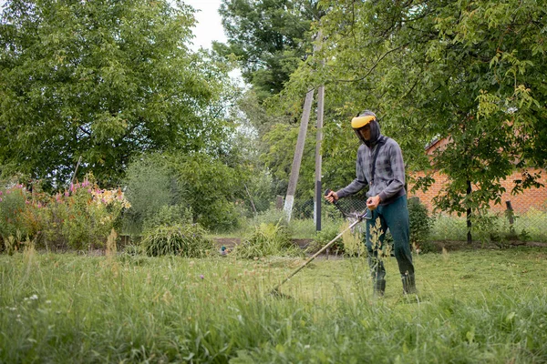 Man mowing the lawn in his garden. Gardener cutting the grass. Lifestyle