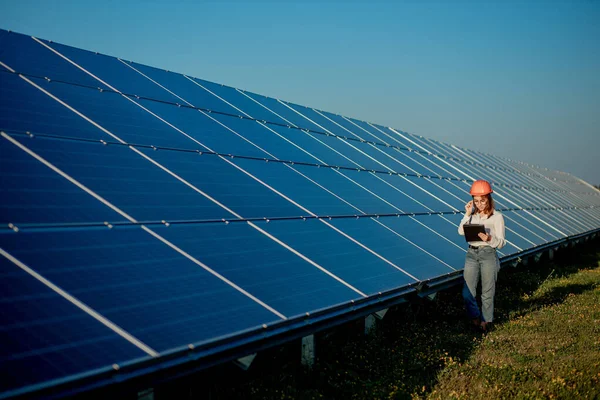 Inspector Engineer Woman Holding Digital Tablet Working in Solar Panels Power Farm, Photovoltaic Cell Park, Green Energy Concept.