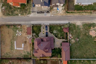 Beton zeminli yeşil çimenli asfalt bahçeli özel bir evin havadan görünüşü.