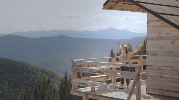 Frau Kommt Morgens Aus Einer Holzhütte Mit Bergblick — Stockvideo