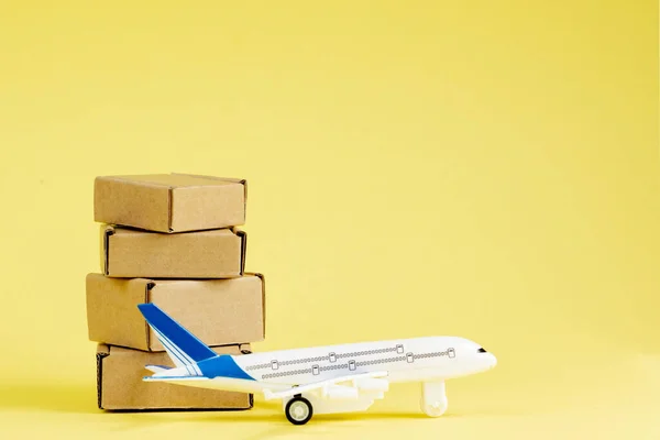 Airplane and stack of cardboard boxes. concept of air cargo and parcels, airmail. Fast delivery of goods and products. Cargo aircraft. Logistics, connection to hard-to-reach places. Banner, copy space.