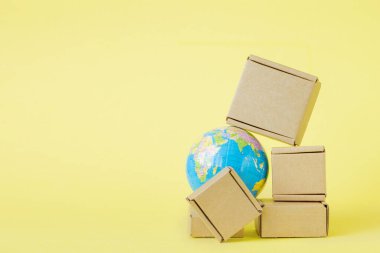 Dünya küresi kutularla çevrili. Küresel iş ve malların uluslararası taşımacılığı. Nakliye, dünya ticareti ve ekonomi. Dağıtım, ithalat ihracat. Ürün cirosu.