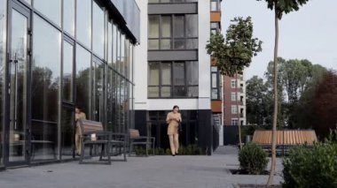 Yetişkin Kafkasyalı Kendine güvenen Genç İş Kadını Modern Ofis Binası 'nın dışında telefonla konuşuyor.