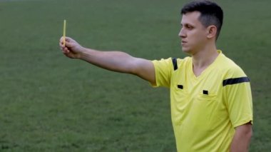 Futbol hakemi ıslık çalıyor ve penaltı ve sarı, kırmızı kart gösteriyor.