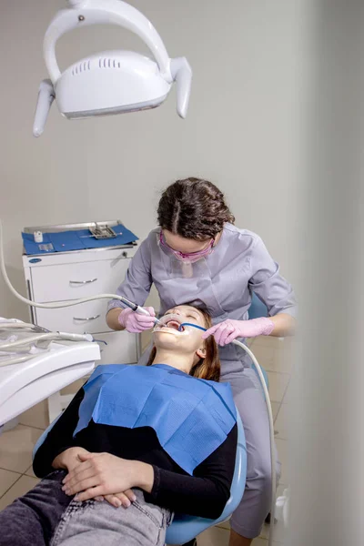 磨牙。牙科服务。牙科医生在牙科诊所为年轻的女病人清洁专业的牙齿。四.清理结束计划 — 图库照片