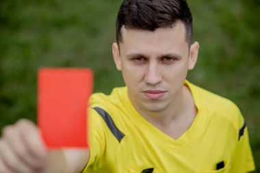 Futbol hakemi, futbol stadyumundaki bir oyuncuya sarı kartı gösterecek..