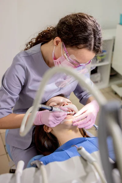 去牙科诊所看病的成年妇女 牙科医生手戴橡胶防护手套 用白色抛光石治疗病人 — 图库照片