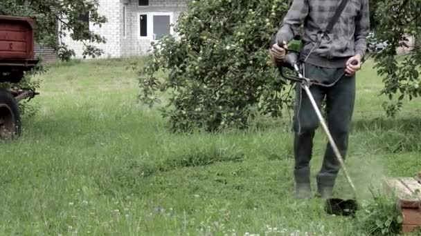 Arbetare Med Gasgräsklippare Händerna Klipper Gräs Framför Huset Trimmer Händerna — Stockvideo