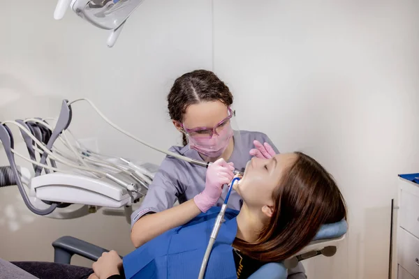 去牙科诊所看病的成年妇女 牙科医生手戴橡胶防护手套 用白色抛光石治疗病人 — 图库照片