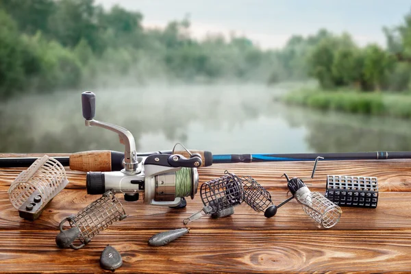 湖を背景にテーブルの上で釣りのタックルとアクセサリー 選択的フォーカス — ストック写真