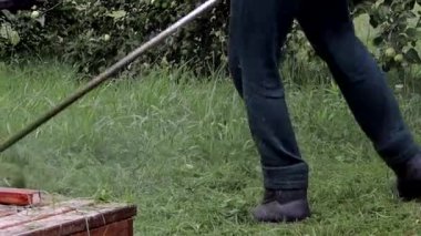 Elinde çim biçme makinesiyle evin önünde çim biçen bir işçi. Bir adamın ellerinde budayıcı. Bahçıvan çimleri biçiyor. Yaşam biçimi.