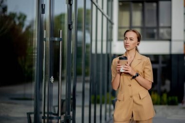 Akıllı telefonlu beyaz bir kadın sokak arkasındaymış.