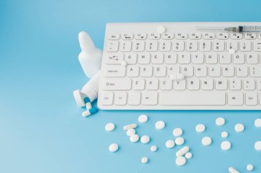 İlaç ve klavyeli alışveriş arabası oyuncağı. Haplar, su toplayan paketler, tıbbi şişeler, termometre, mavi arka planda koruyucu maske. - Evet. Sağlık ve internet alışverişi. Metniniz için en üstteki görünüm.