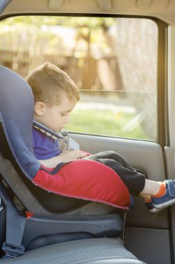 3-4 yaşındaki tatlı çocuk güvenli araba koltuğunda oturuyor ve aile seyahati sırasında araba ile ağlıyor, kötü ruh hali, negatif duygu, yetiştirilme ve aile kavramı, yazlık açık hava..