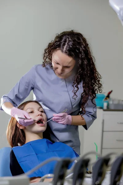 健康检查 口腔科中心的牙科医生正在用牙科工具对妇女的牙齿进行检查 — 图库照片