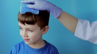 Eldivenli çocuk doktoru küçük bir çocuktaki bit ve bitleri kontrol edecek. Anaokulunda pediküloz, kafa ve saçın önleyici muayenesi