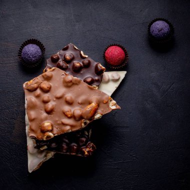 Çikolatalı yer mantarı, çikolata parçaları ve siyah arka planda uçan kakao tozu..