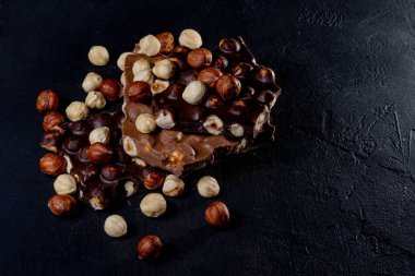 Siyah arka planda fındıklı siyah beyaz çikolata. .